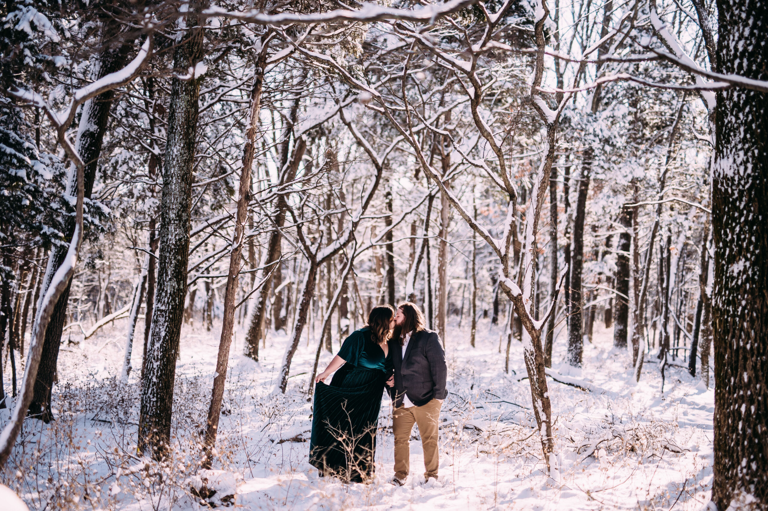 winter engagement photo inspiration of a cute couple holding hands and walking through a snow covered forest in St Louis, Missouri, perfect example of relaxed natural artistic engagement and wedding photography