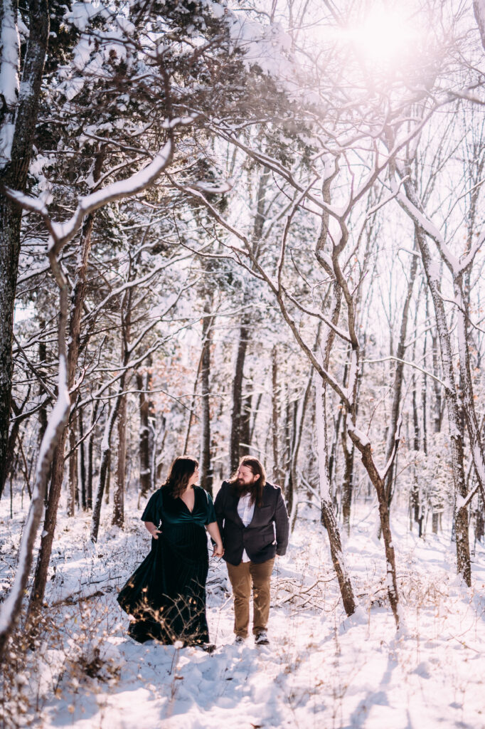 winter engagement photo inspiration of a cute couple in a beautiful forest covered with snow