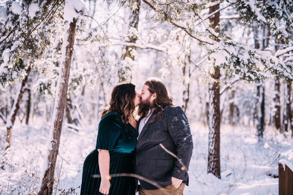 winter engagement photo inspiration of a cute couple in a beautiful forest covered with snow