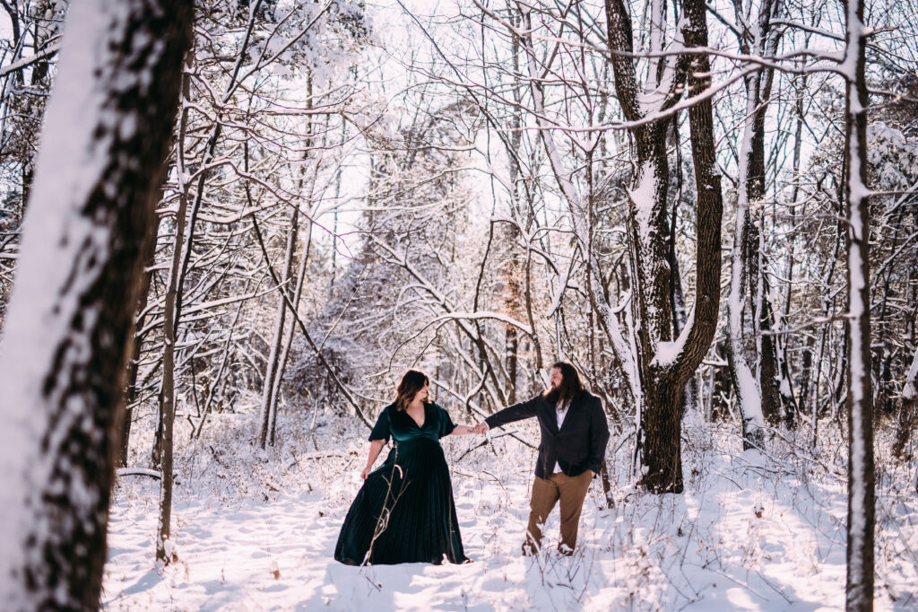 winter engagement photo inspiration of a cute couple in a beautiful forest covered with snow