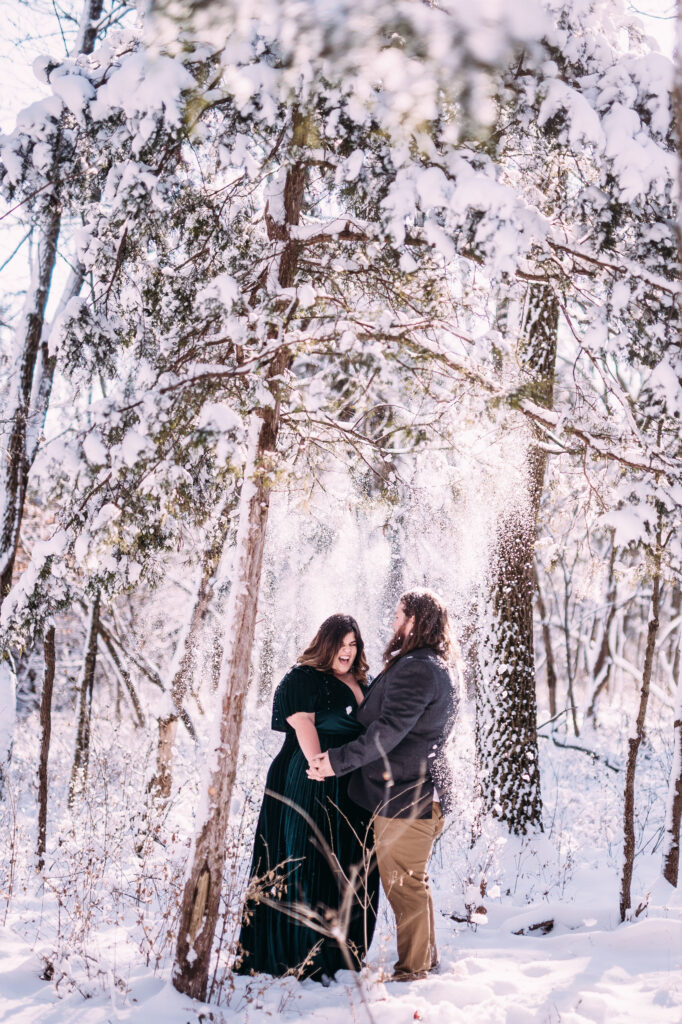 winter engagement photo inspiration of a cute couple holding hands and walking through a snow covered forest in St Louis, Missouri, perfect example of relaxed natural artistic engagement and wedding photography