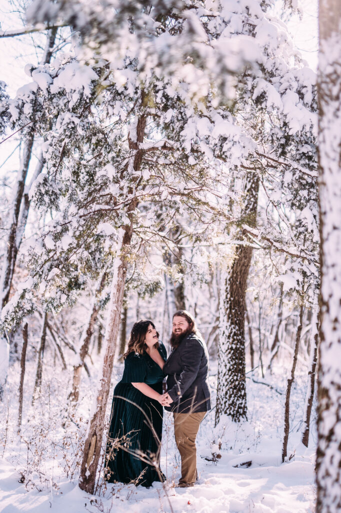 winter engagement photo inspiration of a cute couple holding hands and walking through a snow covered forest in St Louis, Missouri, perfect example of relaxed natural artistic engagement and wedding photography